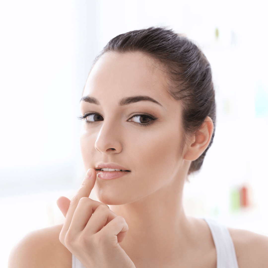 una mujer aplicando balsamo labial natural a su labios