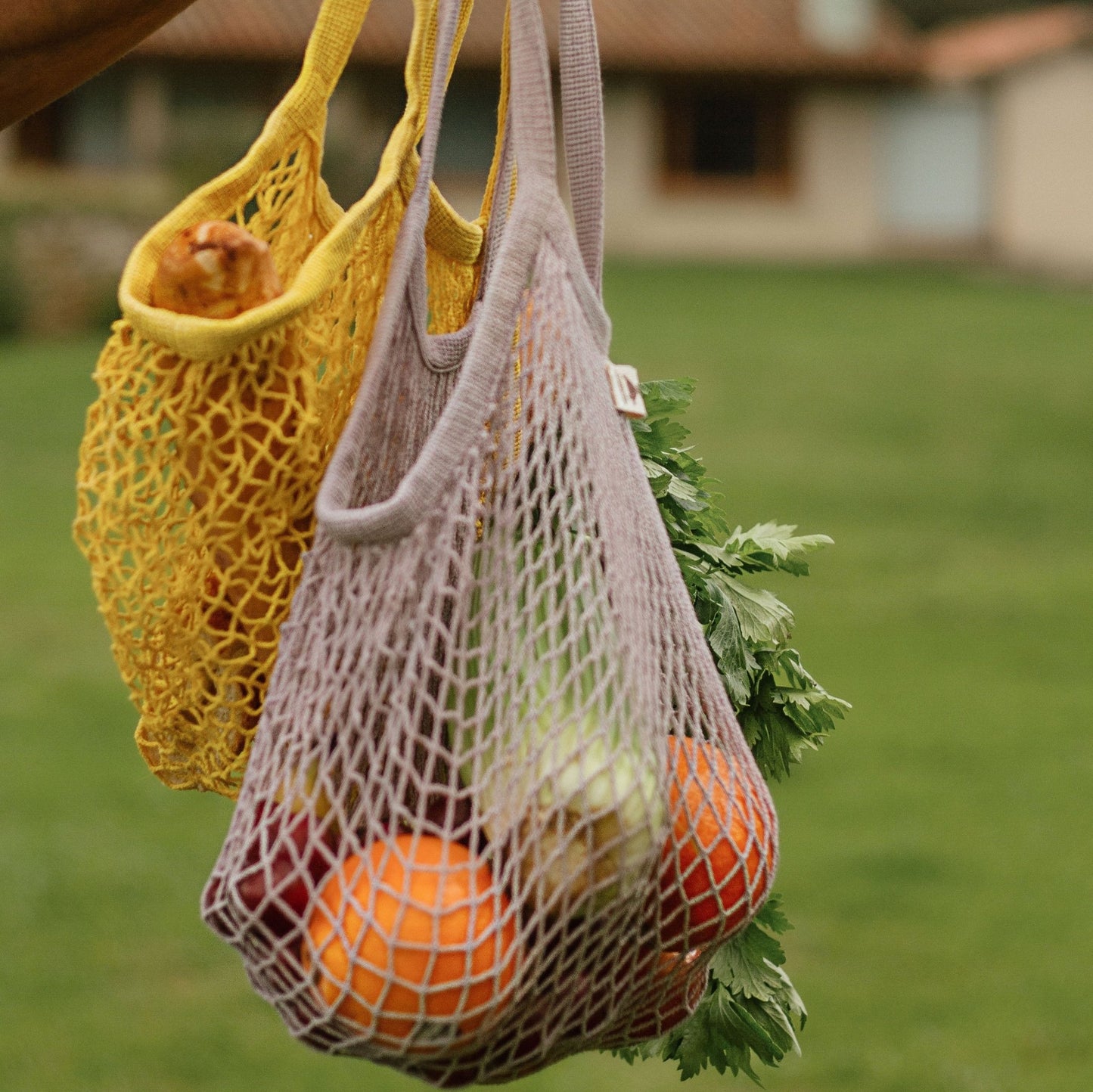 dos Bolsos en crochet llena de frutas cerca