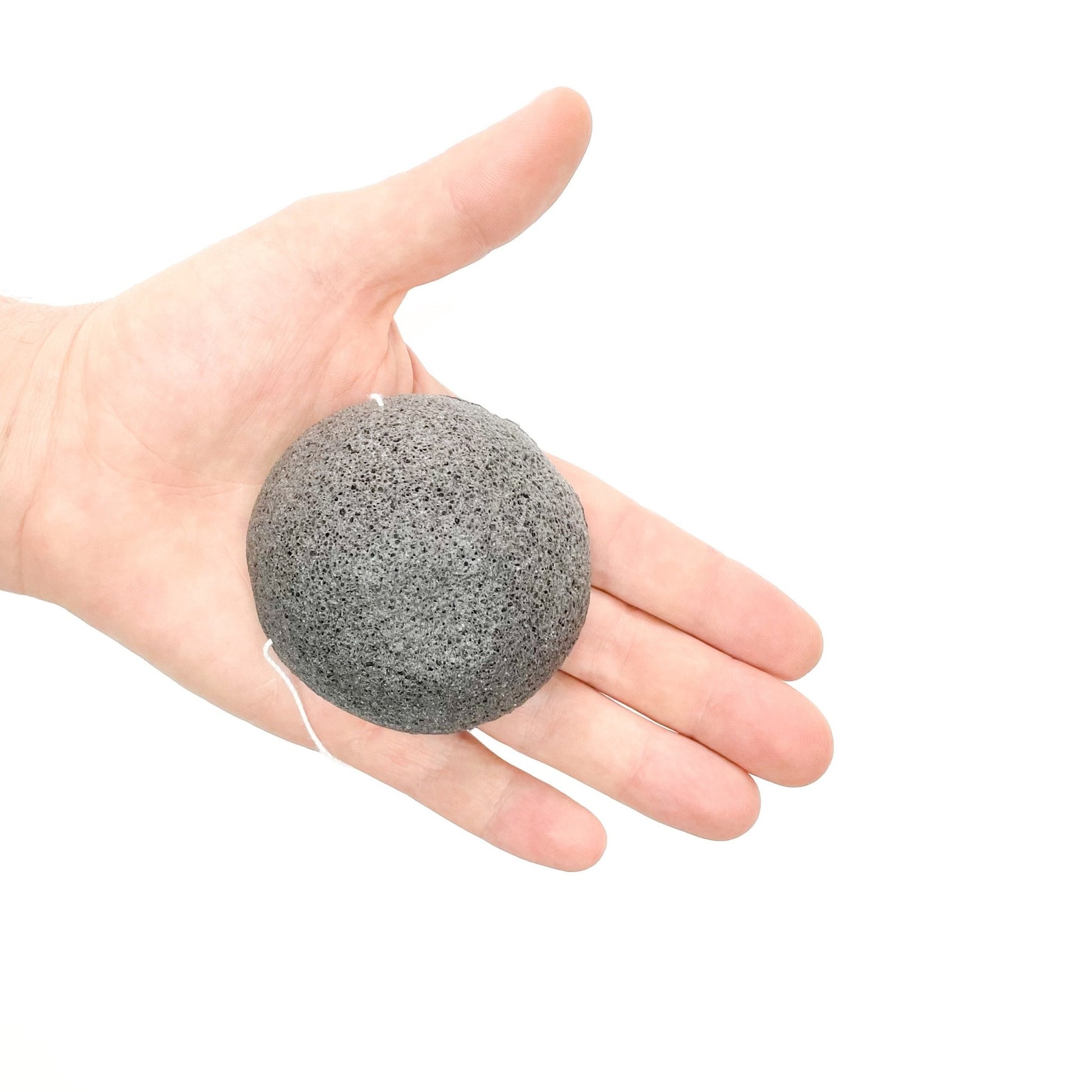 Esponja exfoliante de Konjac negro en un mano 