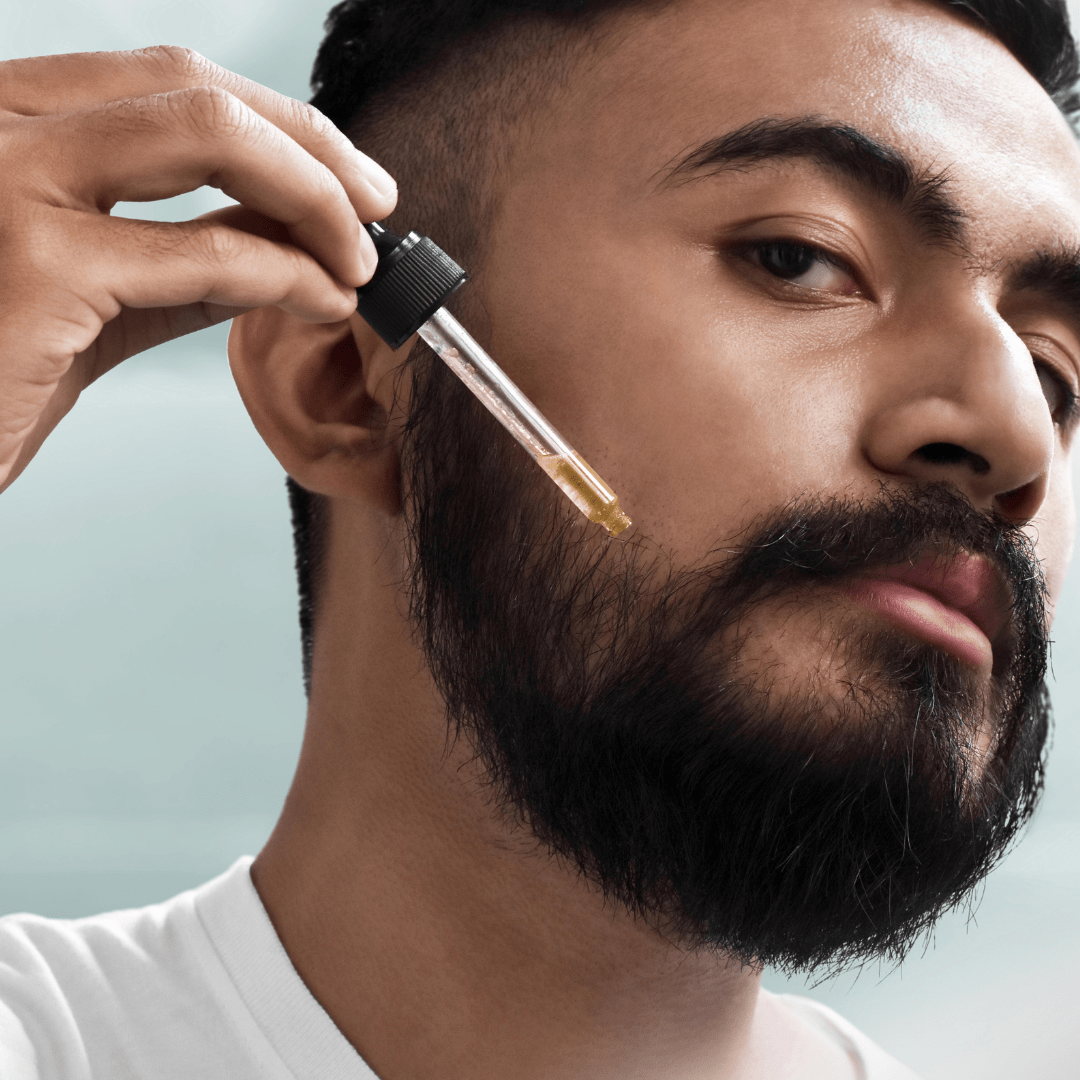 un hombre usando el aceite para barba en su barba 