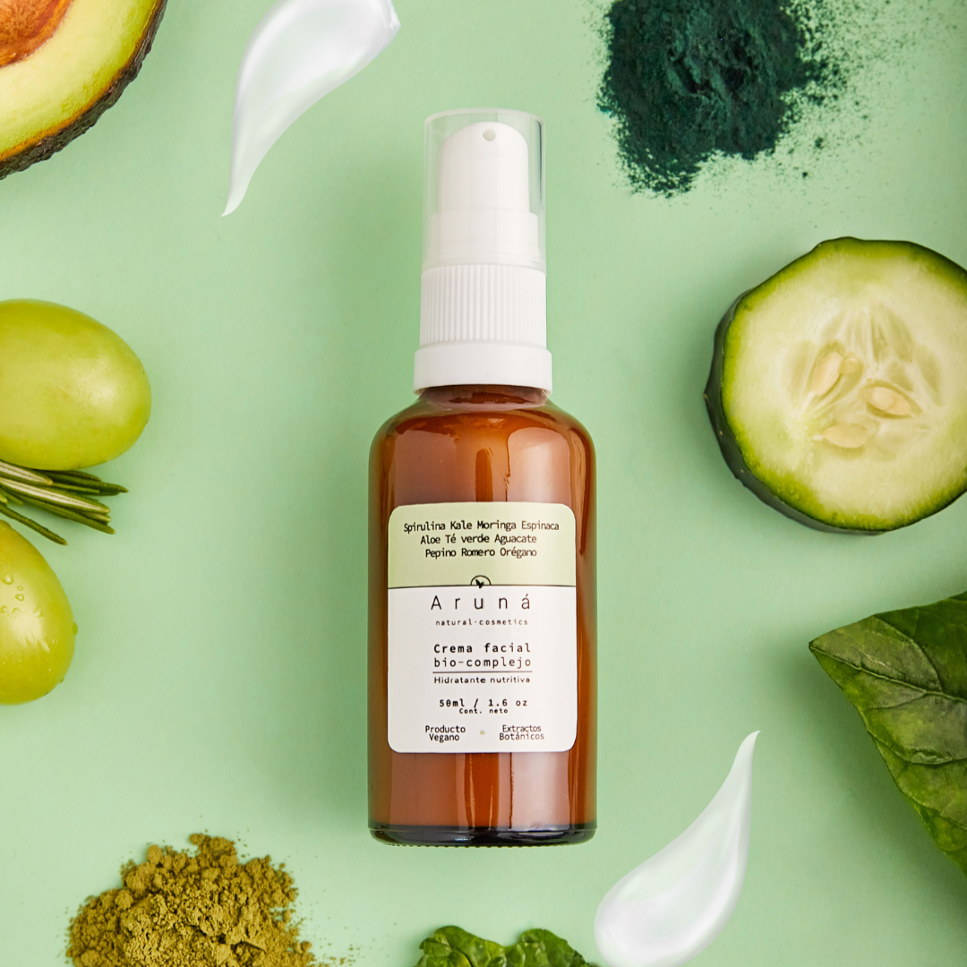 crema facial bio complejo de aruna 30ml con fondo verde menta y varios frutas y vegetales. 